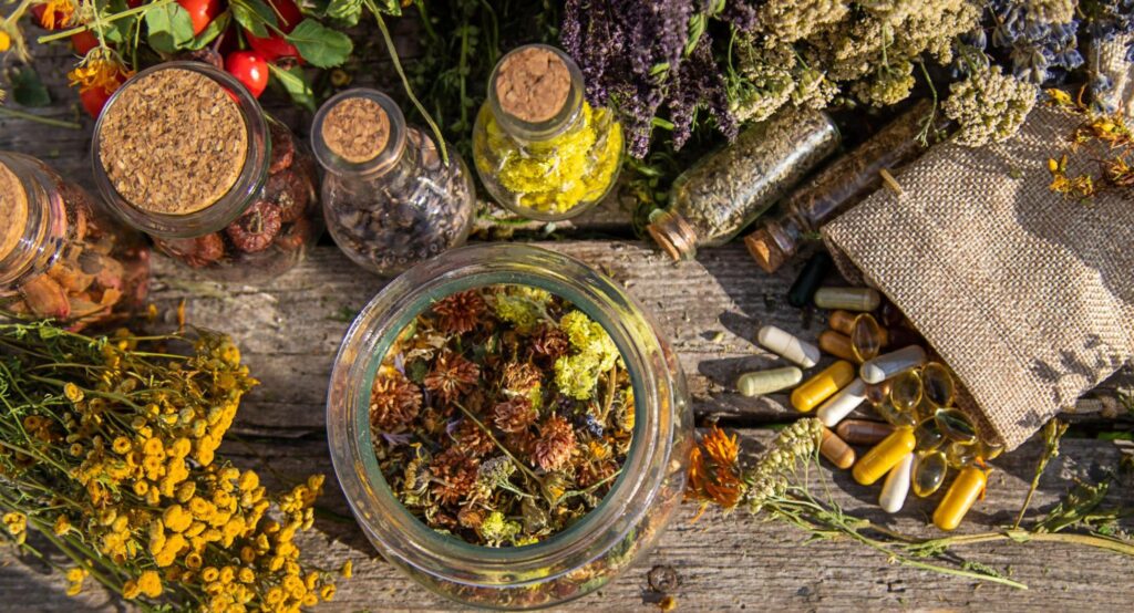 A display of various dried herbs and medicinal tinctures in a garden, representing natural remedies in holistic medicine.