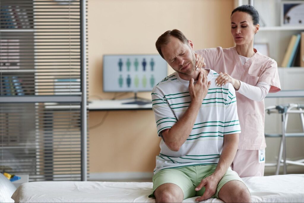 Man in pain next to a female doctor.