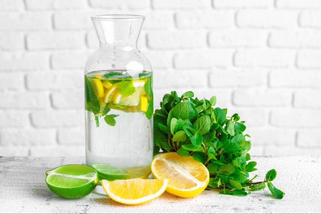 Flavored water in a pitcher with lemon mints and lemons.