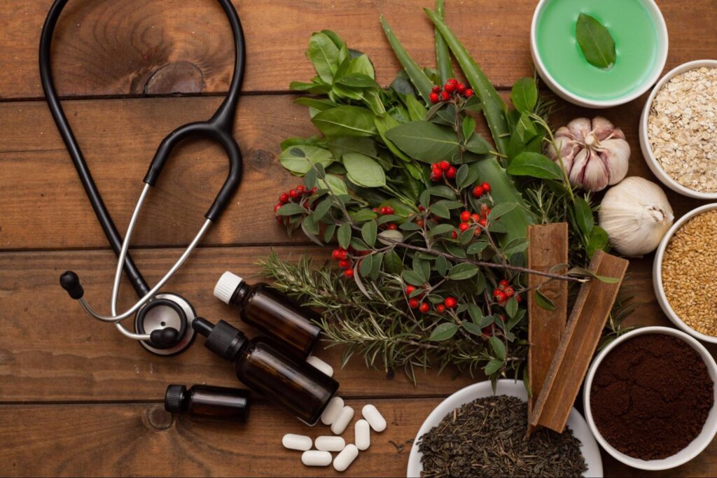 Herbs and spices next to medical tools and bottles of capsules.